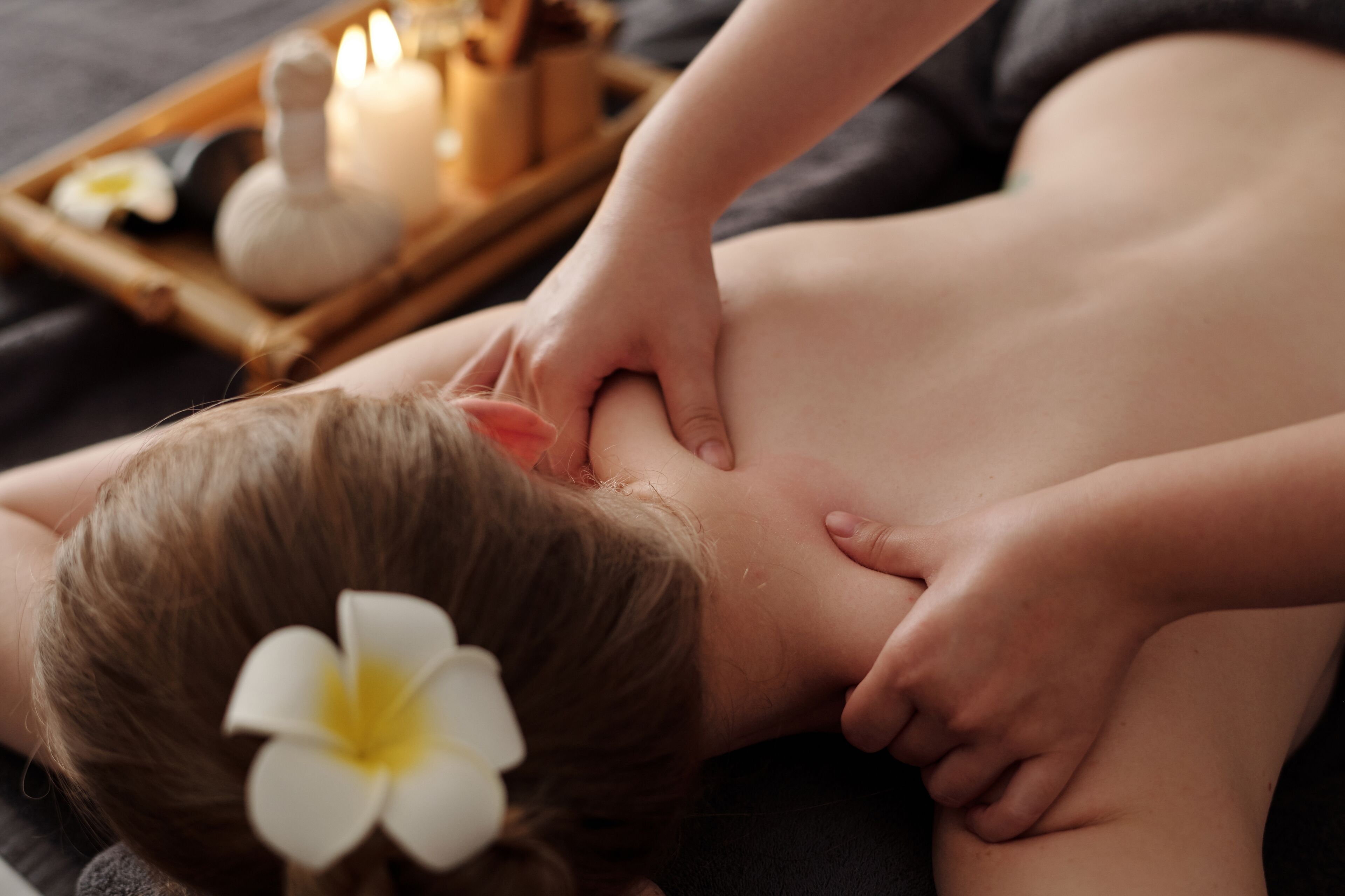A massage session with a tray of candles and a flower.