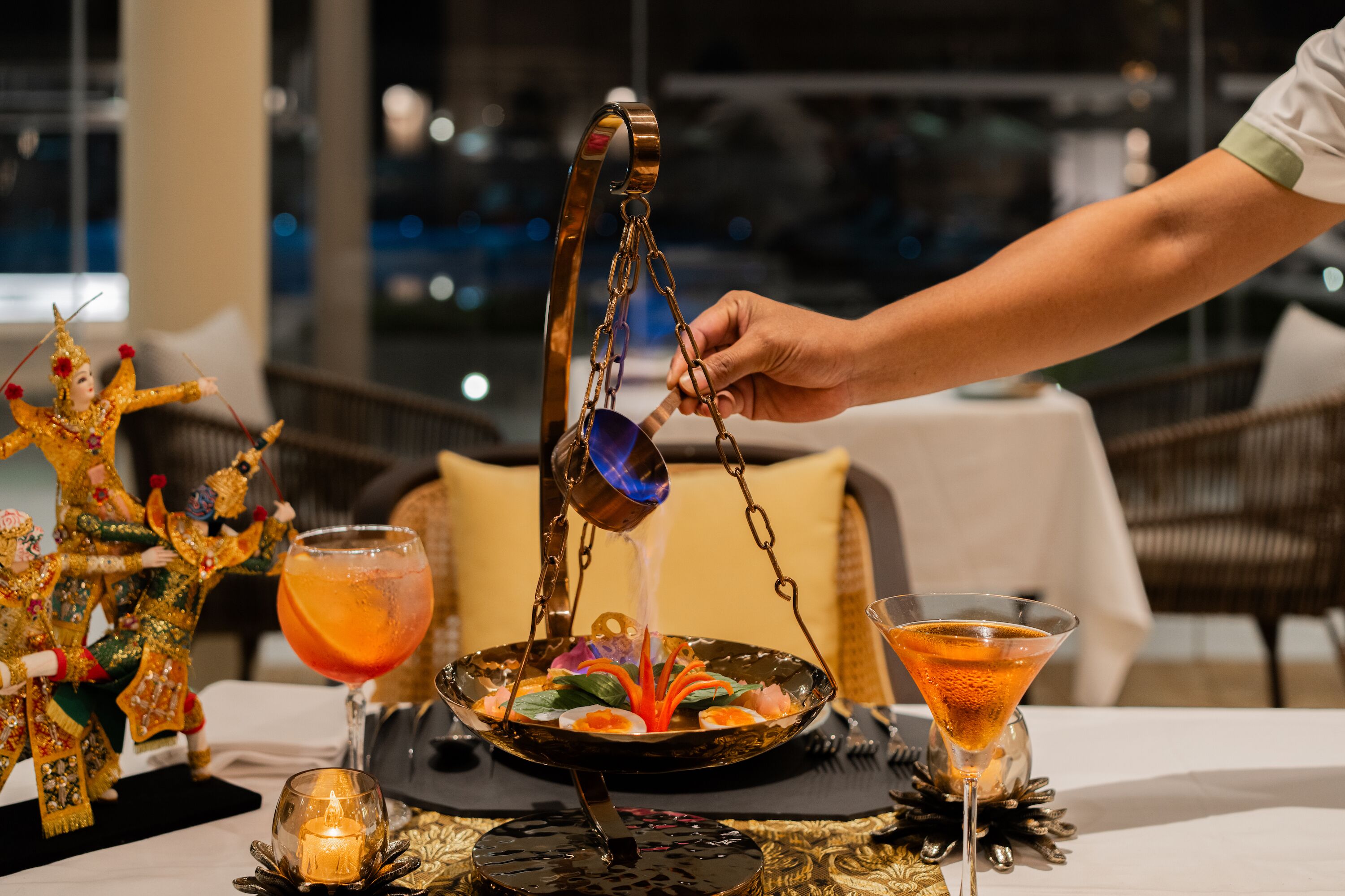 Una mesa con un centro decorativo, una vela y una copa de martini.