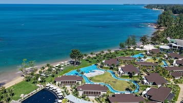 Un resort con múltiples piscinas, acceso a la playa y abundante vegetación.