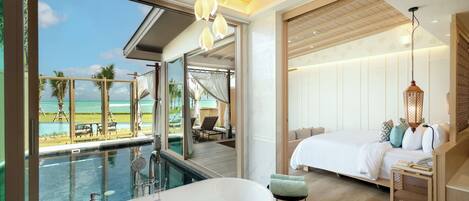 Habitación de hotel moderna con una bañera grande, una cama y vista al océano.
