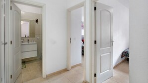 A hallway with a bathroom and a bedroom. - Vacation Apartment 'Beach Front Puertito' with Shared Pool, Private Terrace and Wi-Fi (Güimar)