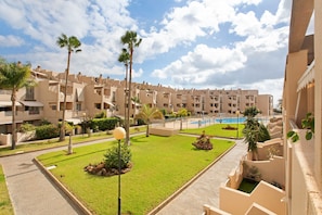 A hotel with multiple-story buildings, a swimming pool, and well-maintained lawns.