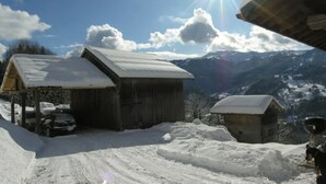 A snow-covered mountain landscape with a wooden cabin and a car parked in front. - Chalet 'L'Échappée Des Rêves' with Mountain View, Private Terrace and Wi-Fi (Verchaix)