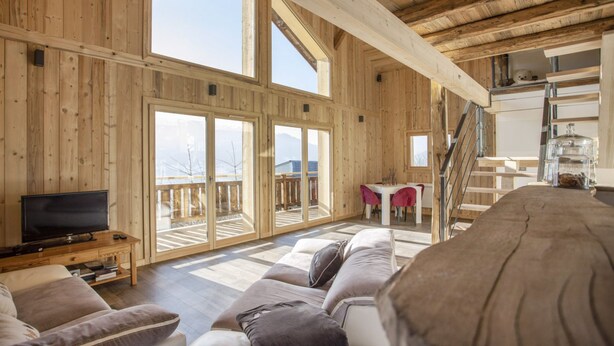 A wooden interior with a TV, sofa, and dining area. - Chalet 'L'Échappée Des Rêves' with Mountain View, Private Terrace and Wi-Fi (Verchaix)