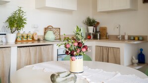 Eine Küche mit einem runden Tisch, einer Blumenvase und diversen Küchenutensilien.