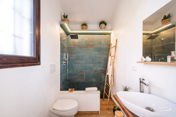 Un baño pequeño con inodoro, bañera y zona de ducha.