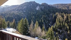 A mountainous landscape with dense forests and snow patches. - Apartment 'Le Petit Bonheur' with Mountain View and Balcony (Modane)