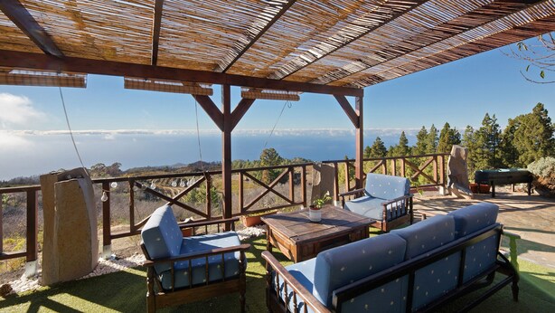 A covered outdoor seating area with wooden furniture and a view of the landscape. - Holiday Home 'Media Pipa' with Sea View, Wi-Fi and Air Conditioning (Puntagorda)
