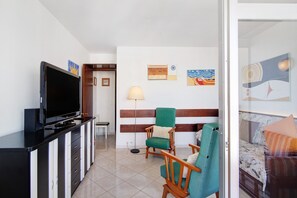 Une chambre d’hôtel équipée d’une télévision, d’un lit, d’un bureau et d’une chaise.