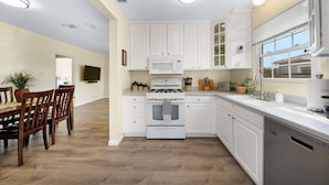 A modern kitchen with white cabinetry, a gas stove, and a dishwasher. - The Succulent House, parking, walk to Bay! (San Diego)