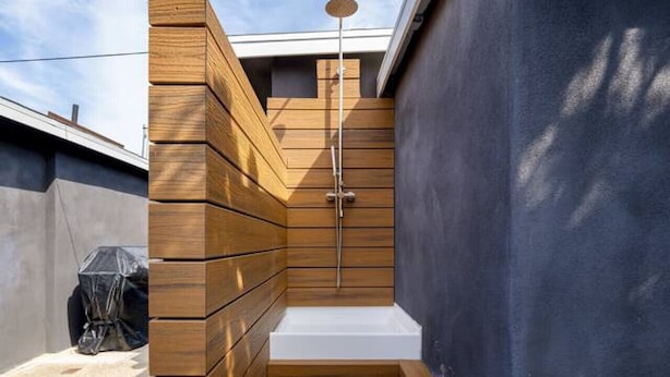 A small wooden outdoor shower with a metal showerhead, steps leading up to it, and a blue wall on one side. - The Succulent House, parking, walk to Bay! (San Diego)