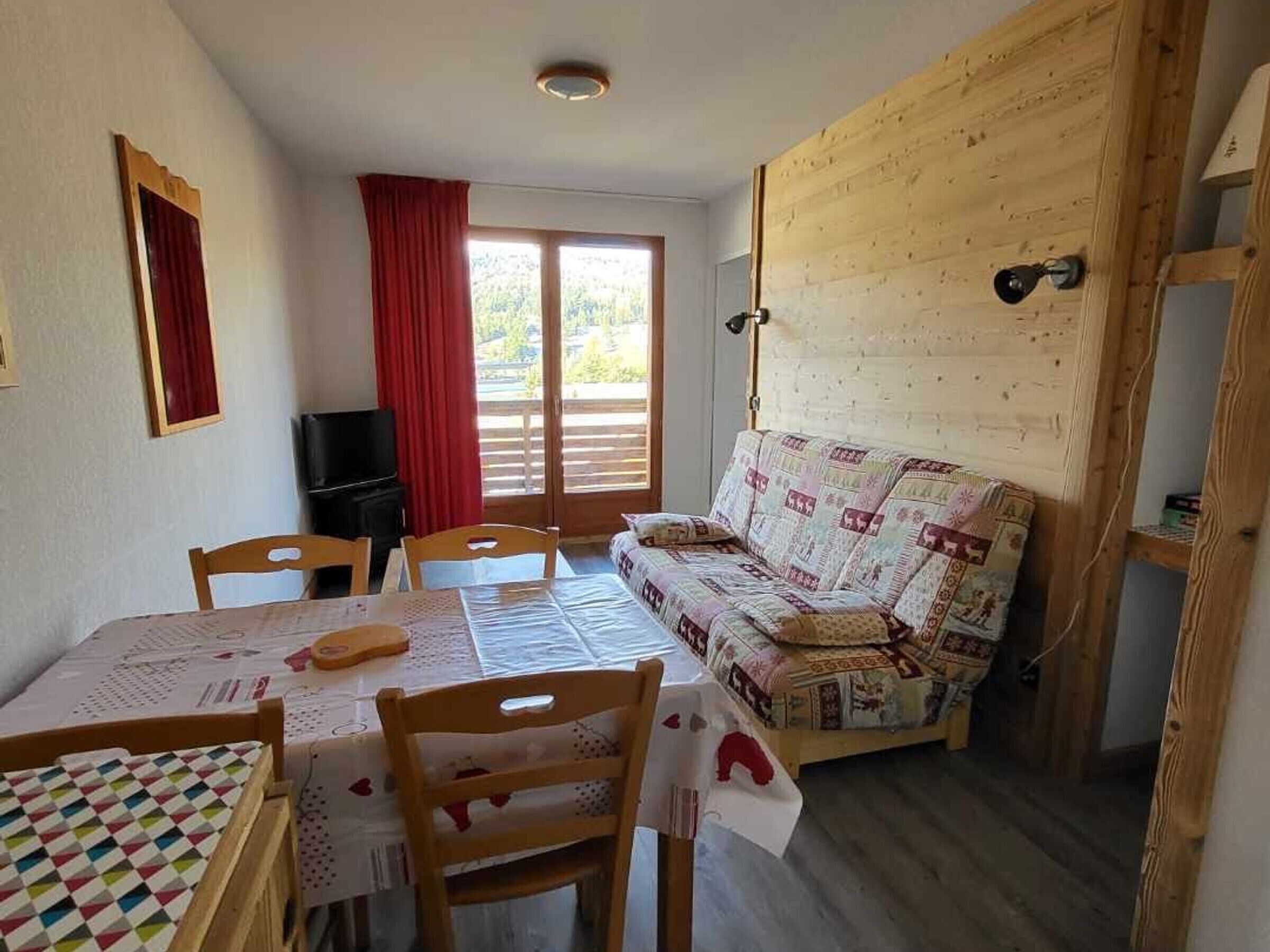 A cozy room with a dining table, chairs, a sofa, and a TV.