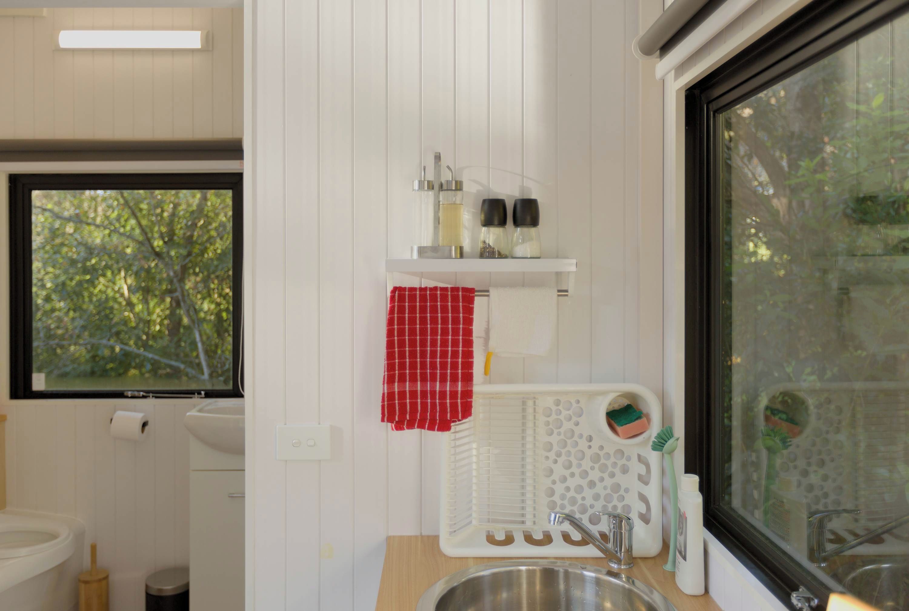 Une petite salle de bain comprenant des toilettes, un lavabo et une fenêtre.