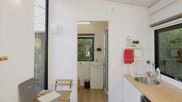 A compact kitchen with a wooden countertop, a sink, and a window.