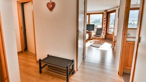 A hallway with wooden flooring, a small table, and a heart-shaped decoration on the wall. - Les Gets - 2BR Apartment for 6 with Balcony and WIFI (Les Gets)