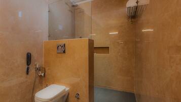 Een moderne badkamer met toilet, douche en een douchecabine met glazen wanden.