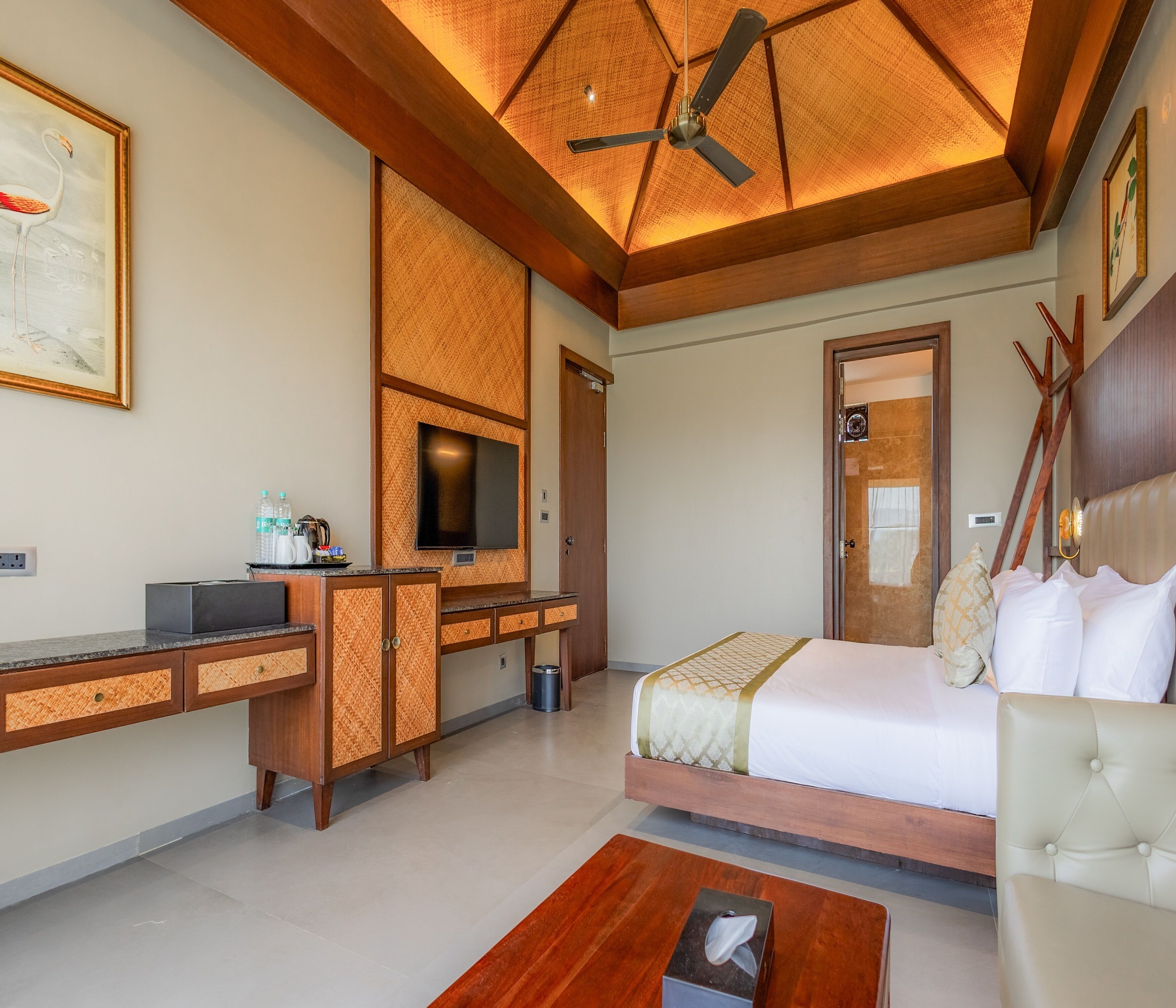 Une chambre d’hôtel équipée d’un lit, d’une télévision, d’un bureau et d’un ventilateur de plafond.