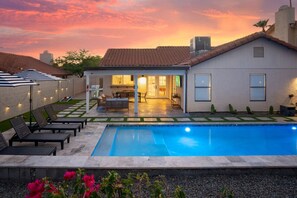 Een modern huis met een zwembad, een terras en een patio.