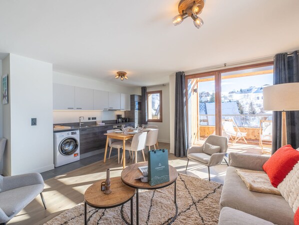 A modern apartment with a kitchen, dining area, and living room.
