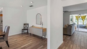 Een moderne woonkamer met een eethoek, een bank en een houten vloer.