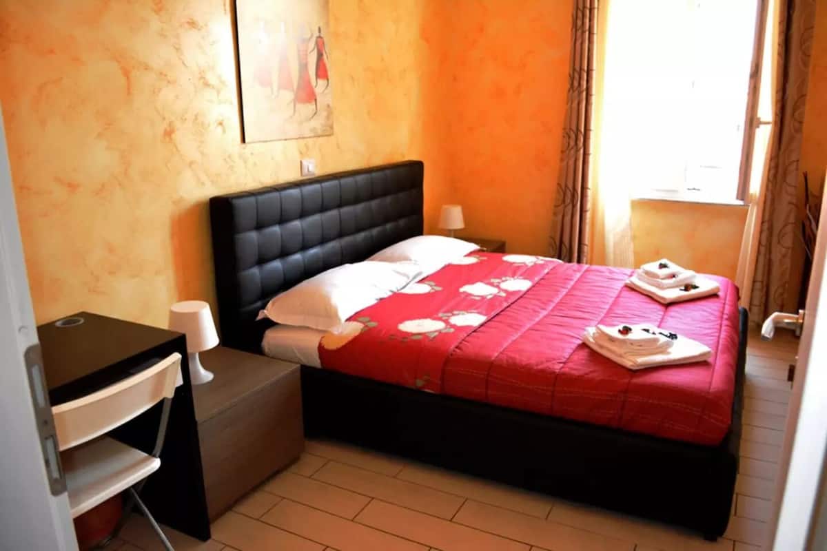 Una habitación de hotel con cama, escritorio y silla.