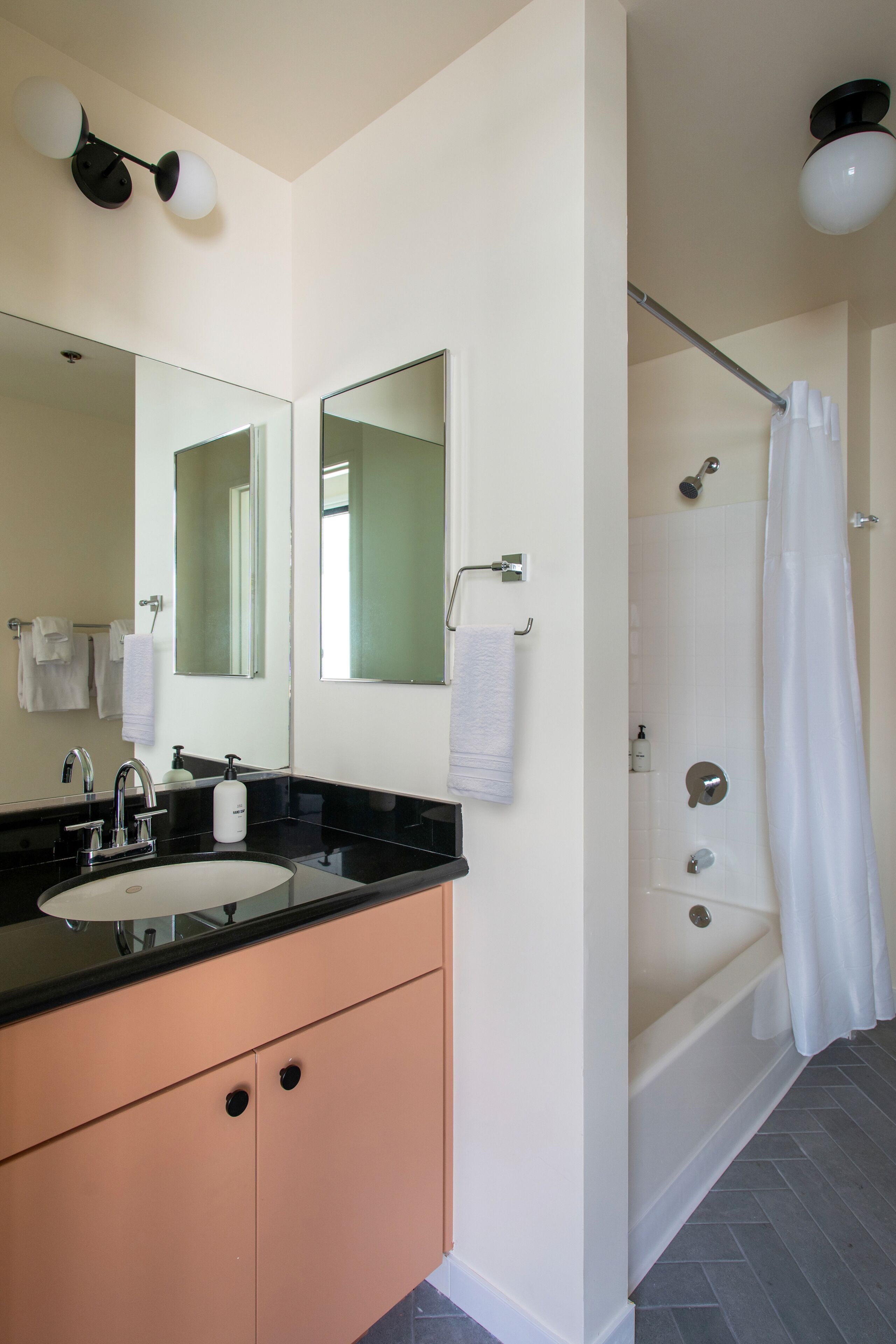 A bathroom with a double sink vanity, a large mirror, a shower with a glass door, and a towel rack.