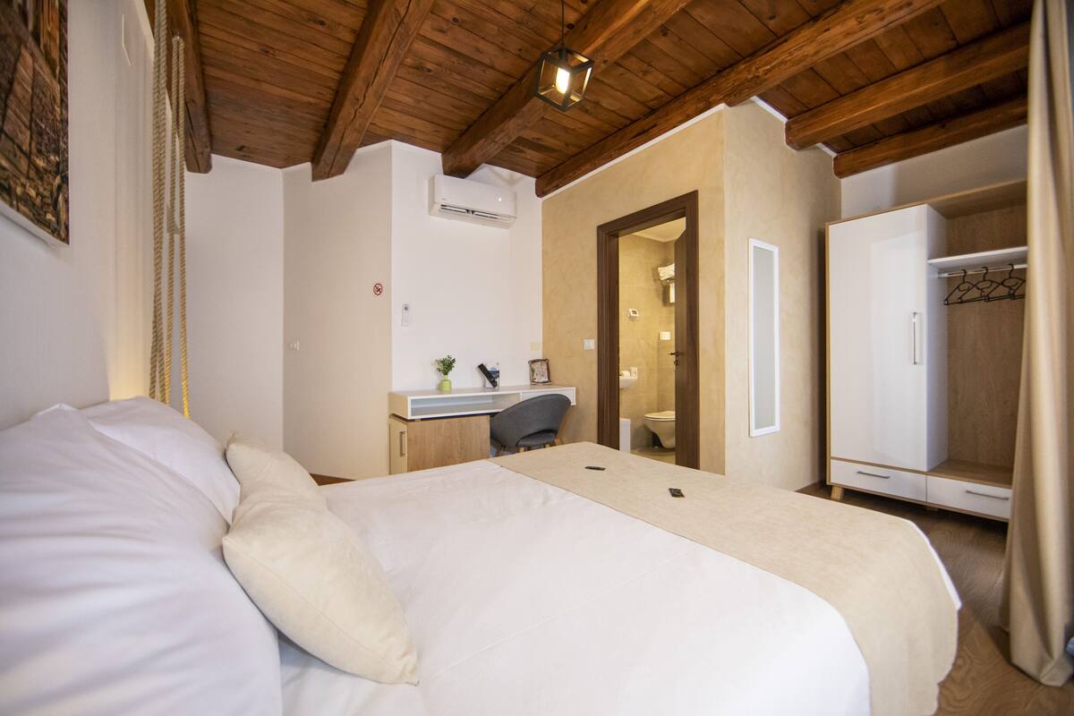 A bedroom with a bed, a desk, a chair, and a wardrobe.