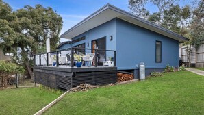Une maison moderne à deux étages, dotée d’un balcon, d’un garage et d’une pelouse bien entretenue.