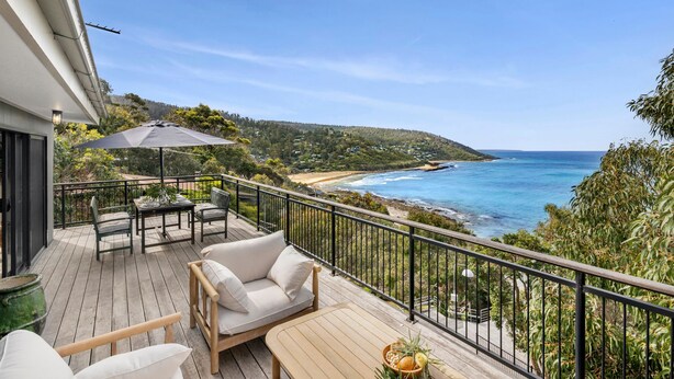 A balcony with a view of the ocean, a table with chairs, and a large umbrella. - Omaroo - Oceanfront Escape in Wye River (Wye River)