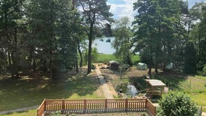 Ein eingezäunter Garten mit Teich, Bäumen und einem kleinen Schuppen.