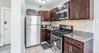 This is a studio apartment with a separate kitchen nook, and a small living nook with a loveseat