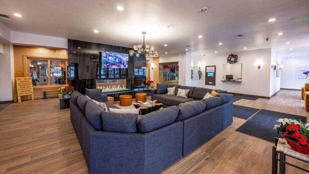 A modern living room with a large sectional sofa, a fireplace, and a television. - Ski-In/Ski-Out at Shadow Ridge (Park City)
