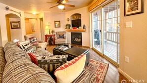 A living room with a sofa, armchairs, a fireplace, and a large window. - Newly Renovated! Fox Bay Retreat at Deer Valley (Heber City)