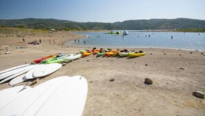 A beach with kayaks lined up and people in the water. - Newly Renovated! Fox Bay Retreat at Deer Valley (Heber City)