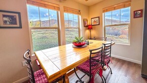 A dining area with a wooden table, four chairs, and a ceiling fan. - Newly Renovated! Fox Bay Retreat at Deer Valley (Heber City)
