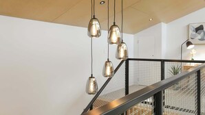 A staircase with a metal railing and pendant lights. - Serenity on Sophia - Spa Pool, Sleeps 6 (Rotorua)