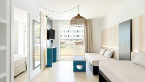 A modern hotel room with a large bed, a TV, and a balcony with a view of buildings. - FERGUS Club Mallorca Waterpark (Calvia)