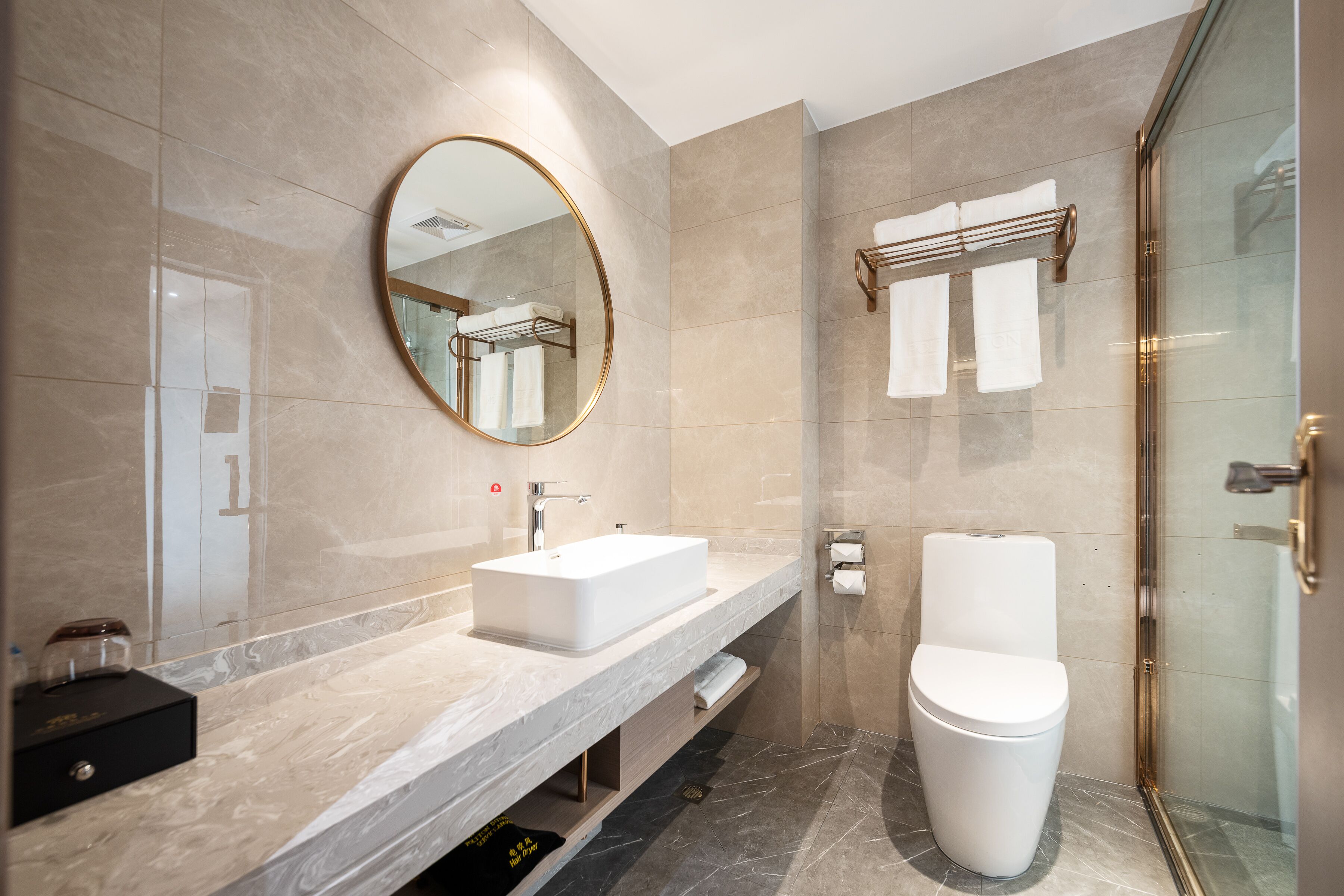 A modern bathroom with a large mirror, a sink, a toilet, and a shower area.