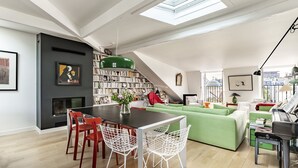 Un salon moderne comprenant un coin repas, un escalier et un piano.