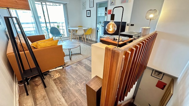 Una sala de estar moderna con un sofá, una mesa de centro y un comedor con sillas.