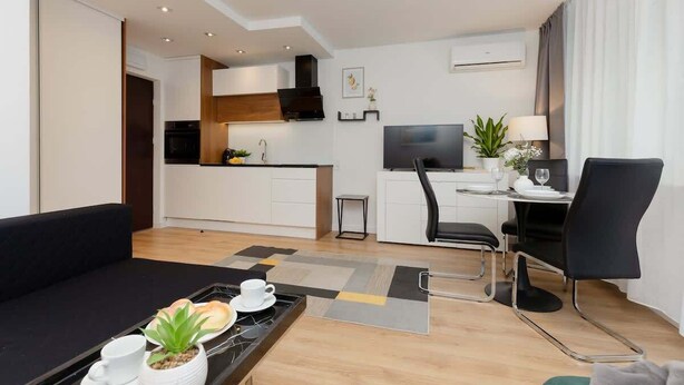 A modern hotel room with a kitchenette, a dining area, and a living space. - Air-conditioned Studio with a Balcony | Close to Pola Mokotowskie (Warszawa)