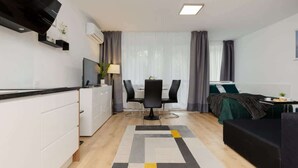 A modern, well-lit room with a kitchen, dining area, and a bed. - Air-conditioned Studio with a Balcony | Close to Pola Mokotowskie (Warszawa)
