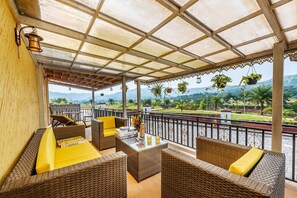 Relax in a serene outdoor space with wicker furniture and a table for reading and refreshment.