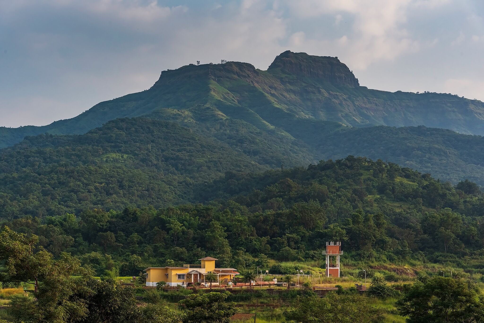 A mountain landscape with a small building featuring a tower.