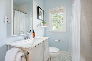 Bathtub, hair dryer, towels, shampoo