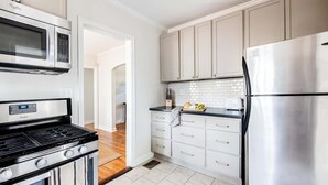 A kitchen with a stainless steel refrigerator, a microwave, and a stove.