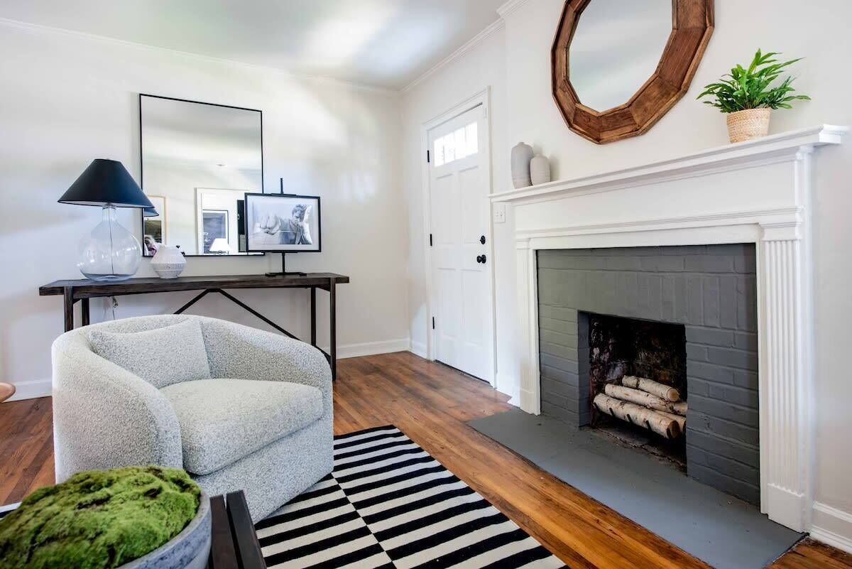 A living room with a fireplace, a sofa, a coffee table, and a rug.