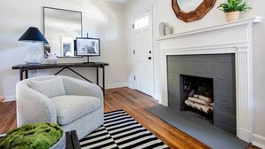 A living room with a fireplace, a sofa, a coffee table, and a rug.