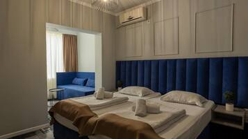 Ein Hotelzimmer mit einem großen Bett, einer kleinen Sitzecke, einem kleinen Tisch und einer Zimmerpflanze.