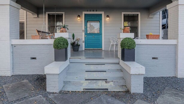 A house with a blue front door, a porch with steps, and two potted plants on either side. - The Hera! Luxury Mansion in Montrose w/ Pool 4BR+1 (Houston)